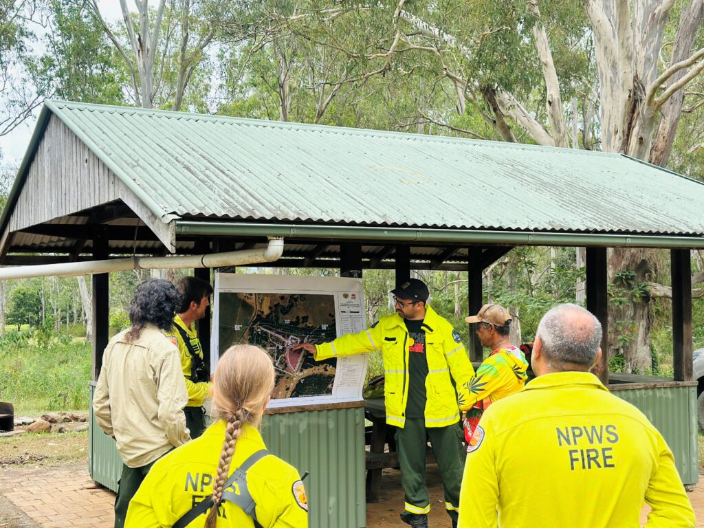 Ngullingah Jugun Aboriginal Corporation CEO Ryan Walker briefs the Ranger Team on the Burn Plan before the cultural burn whilst rangers and National Parks and Wildlife Service rangers look on.